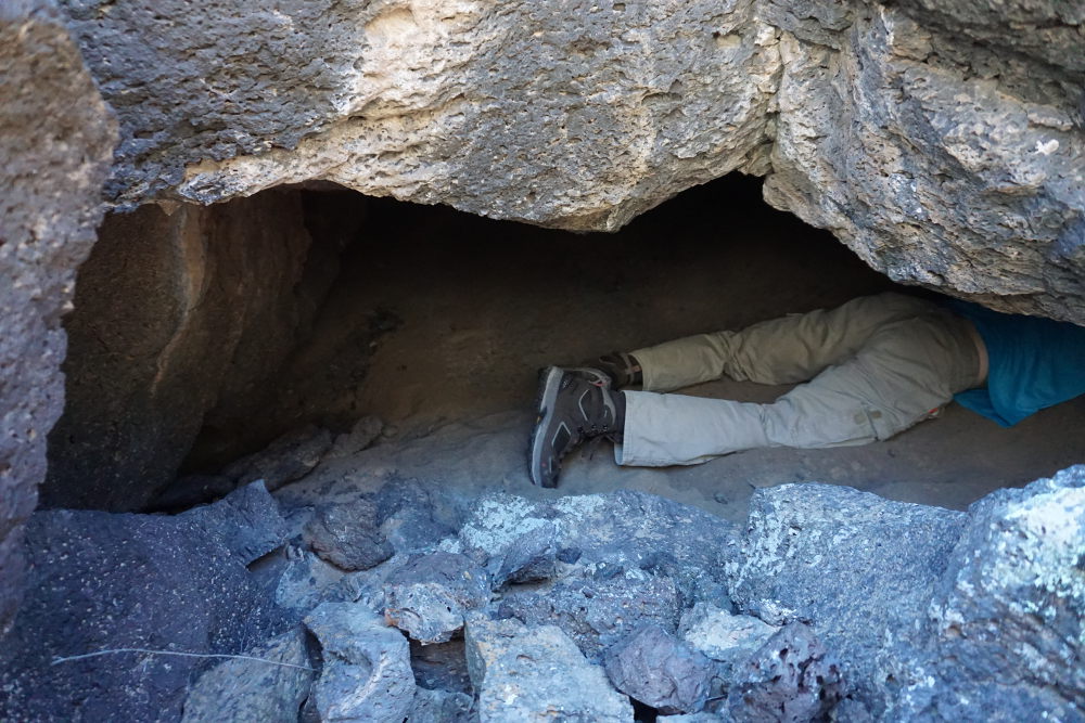 A caver checking a potential cave entry.